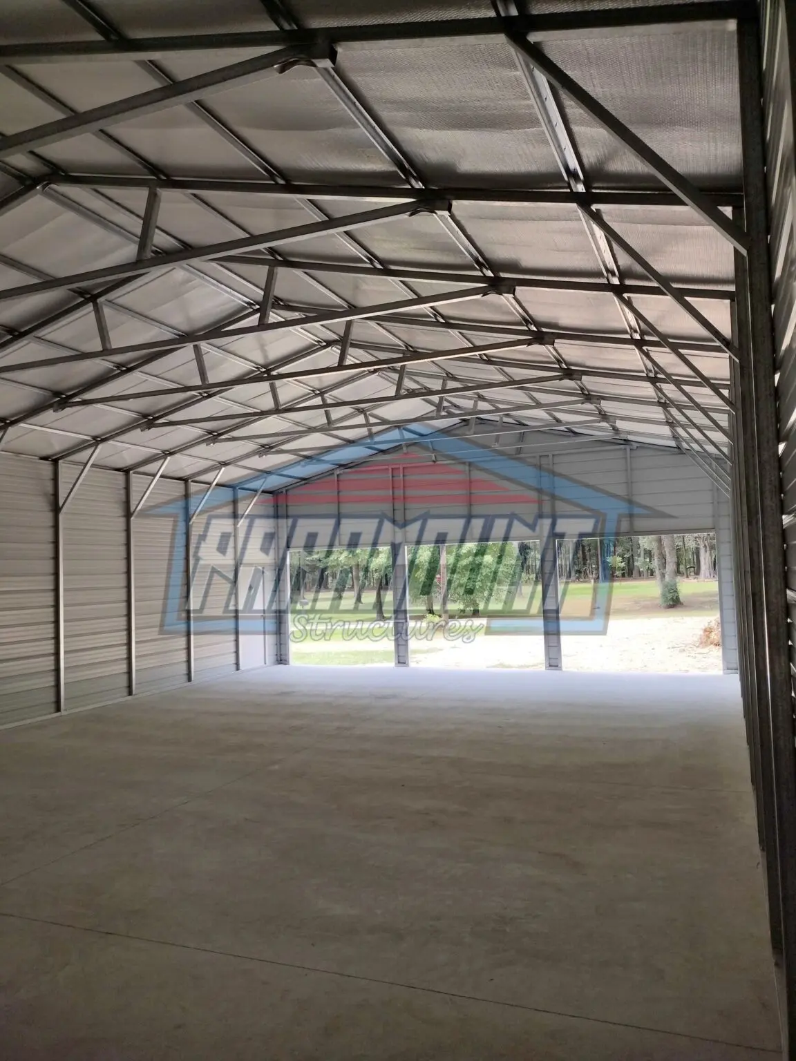 A garage with a metal roof and concrete floor.