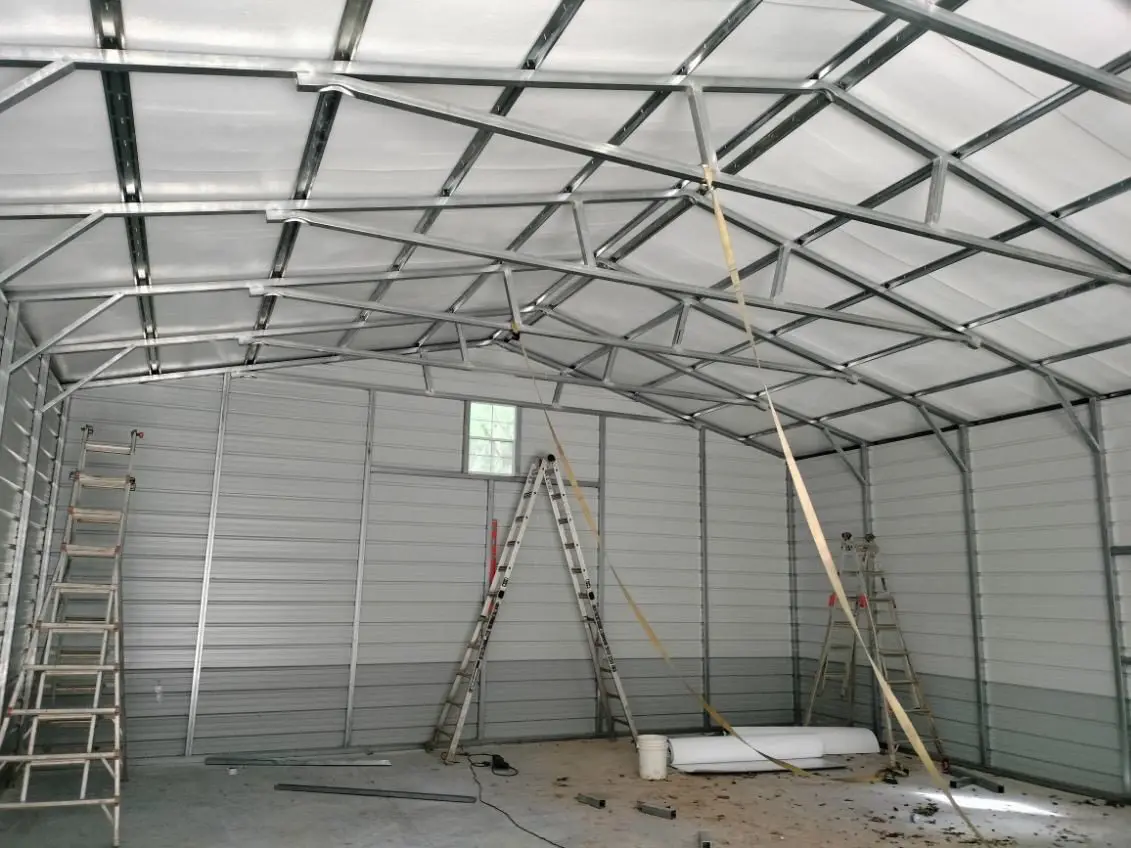 The inside of a metal building is being constructed.
