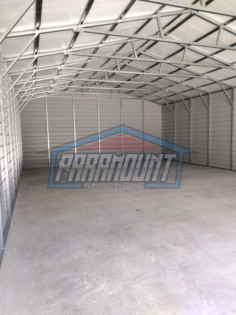 A large garage with a metal roof and concrete floor.