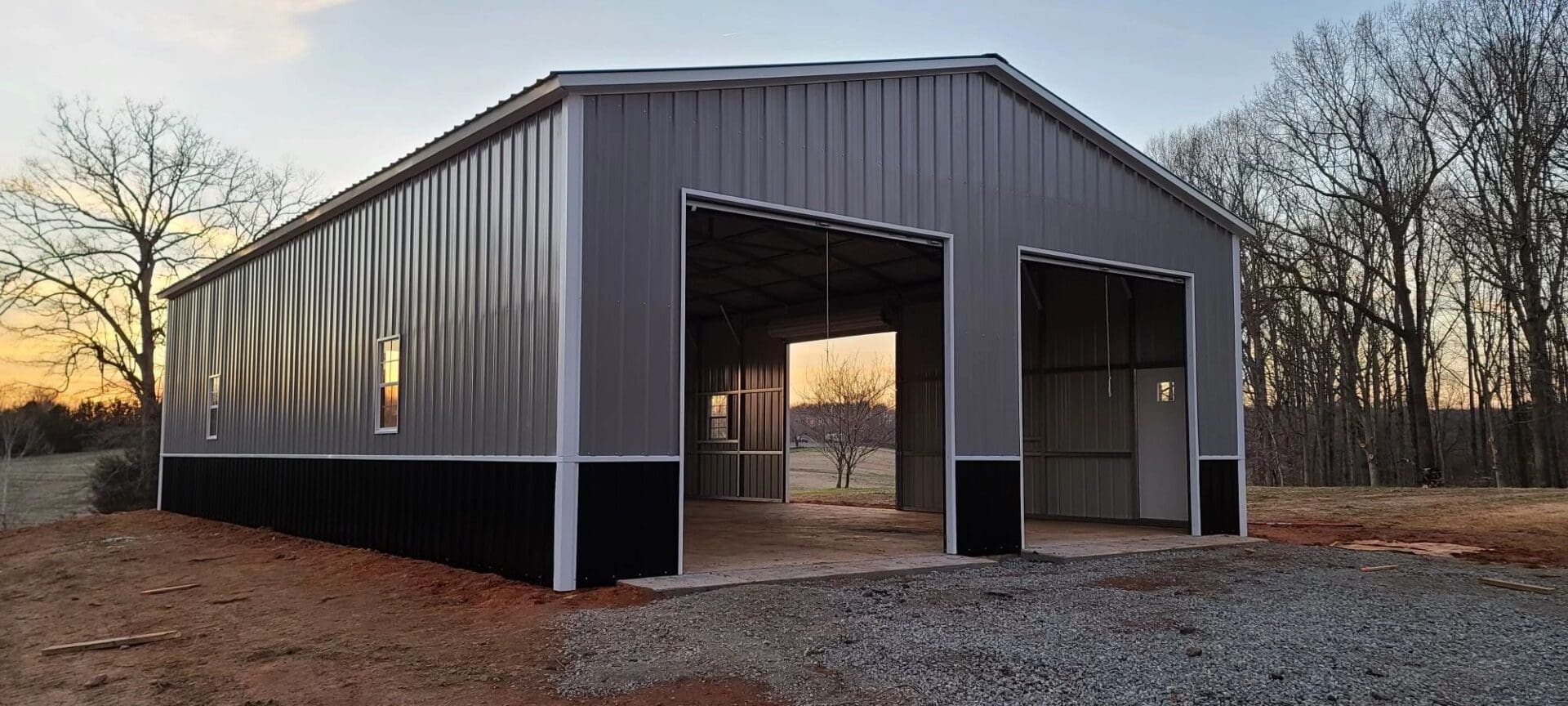 A large metal building with two doors and a door open.