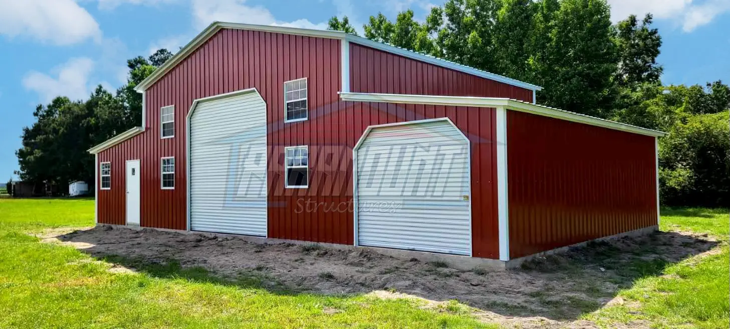 A red and white barn with two garage doors.