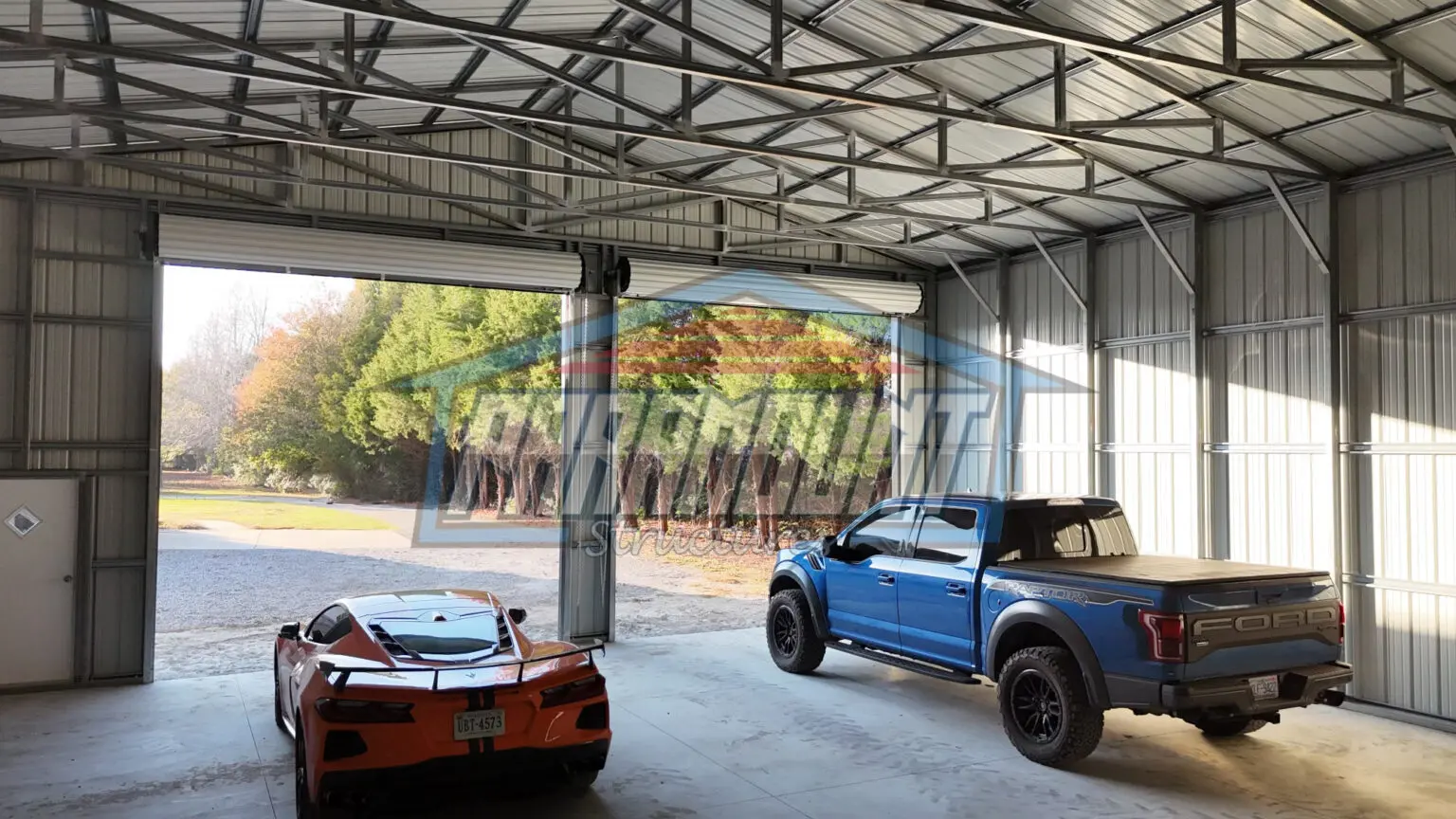 A blue truck and a blue sports car parked inside a building.