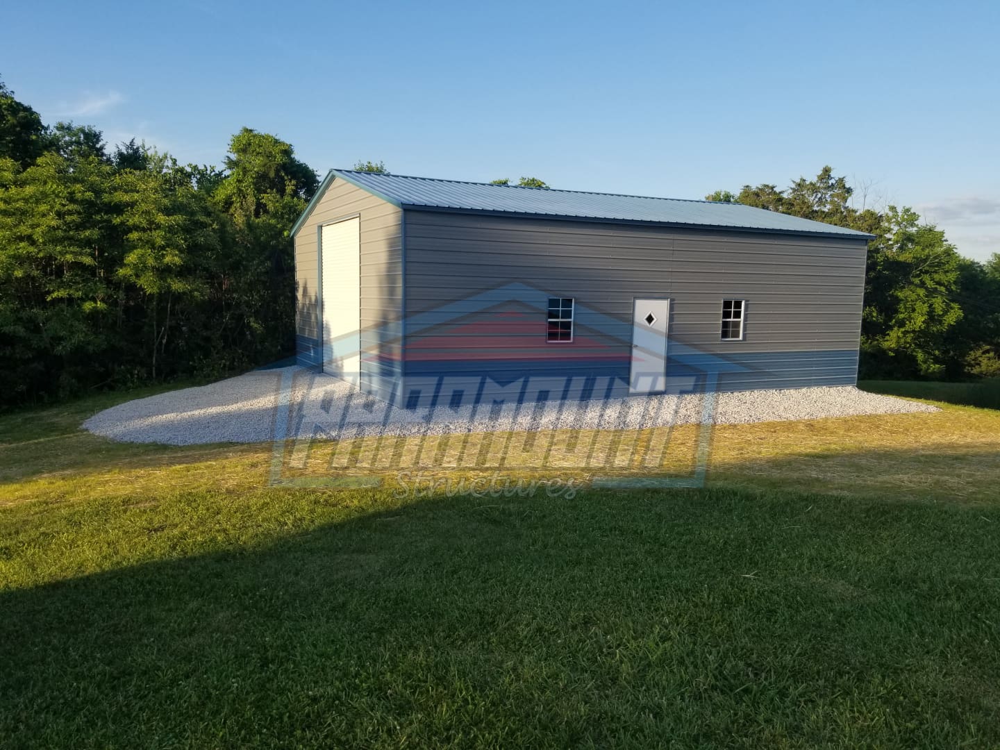 Gray metal building with a garage door.