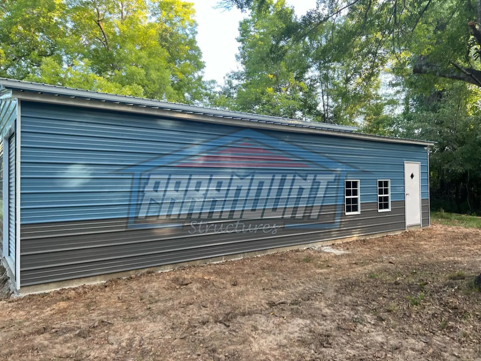 Metal building with two windows and a door.