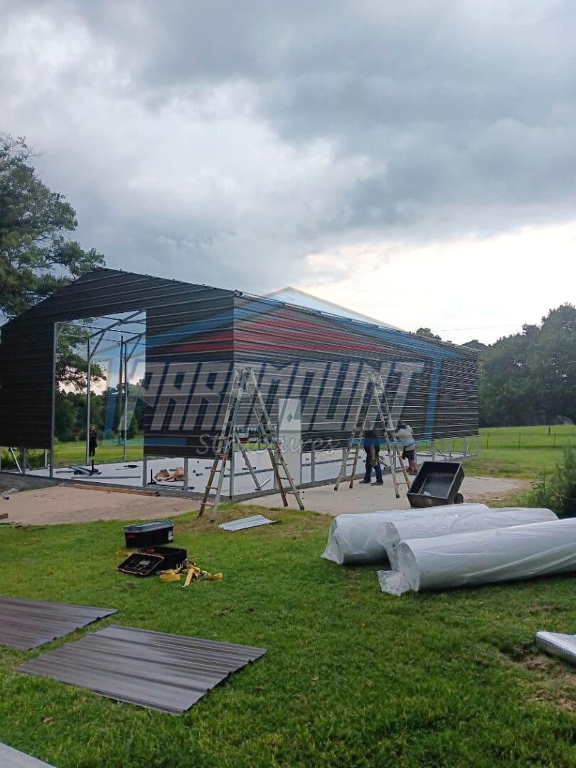 Metal building under construction with ladders.