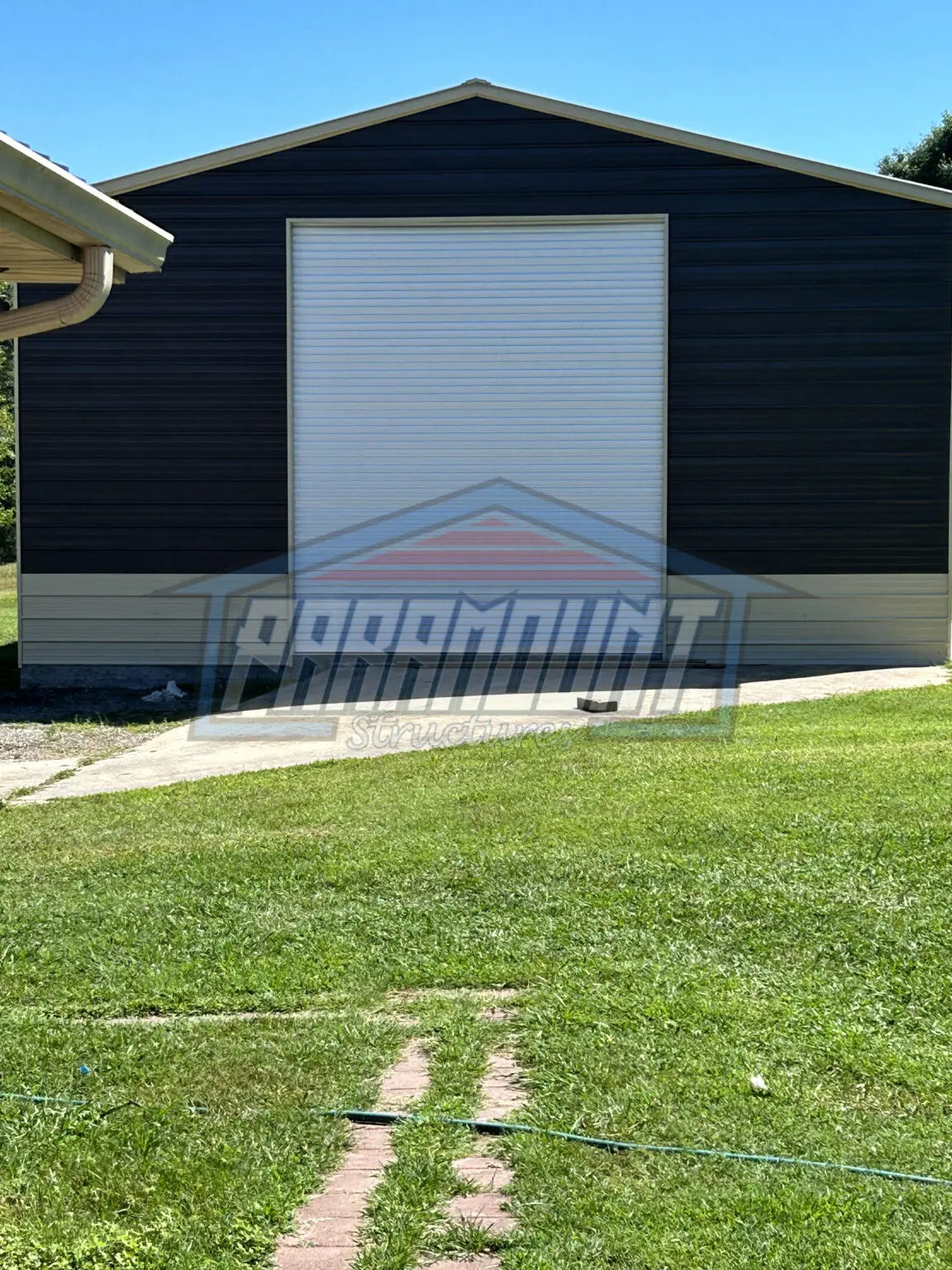 Black metal garage with white door.